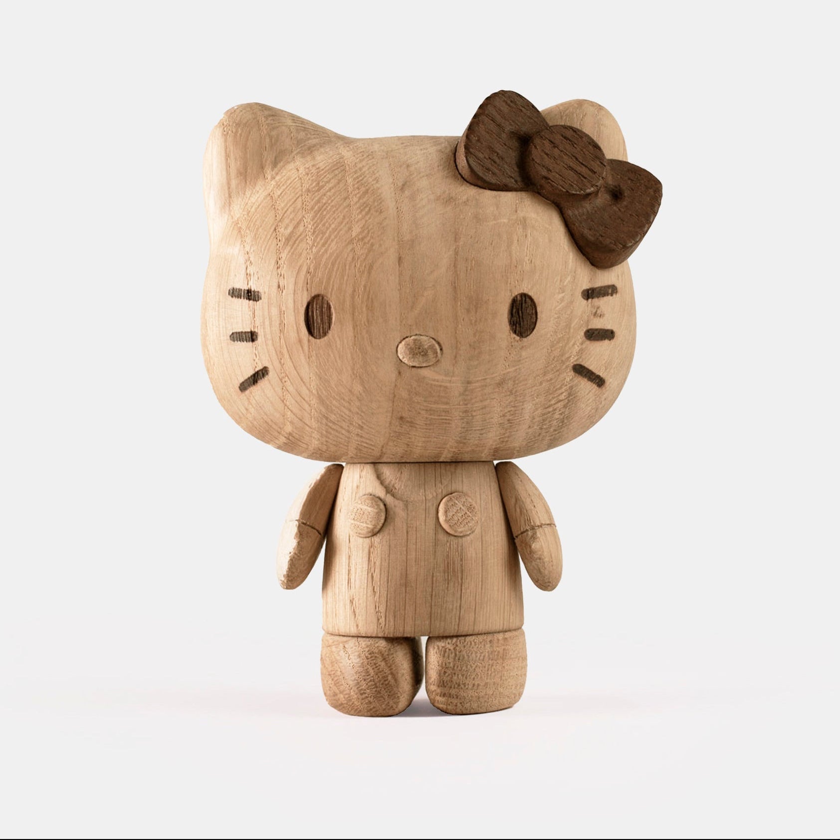 Wooden Hello Kitty figurine with a brown bow on a white background