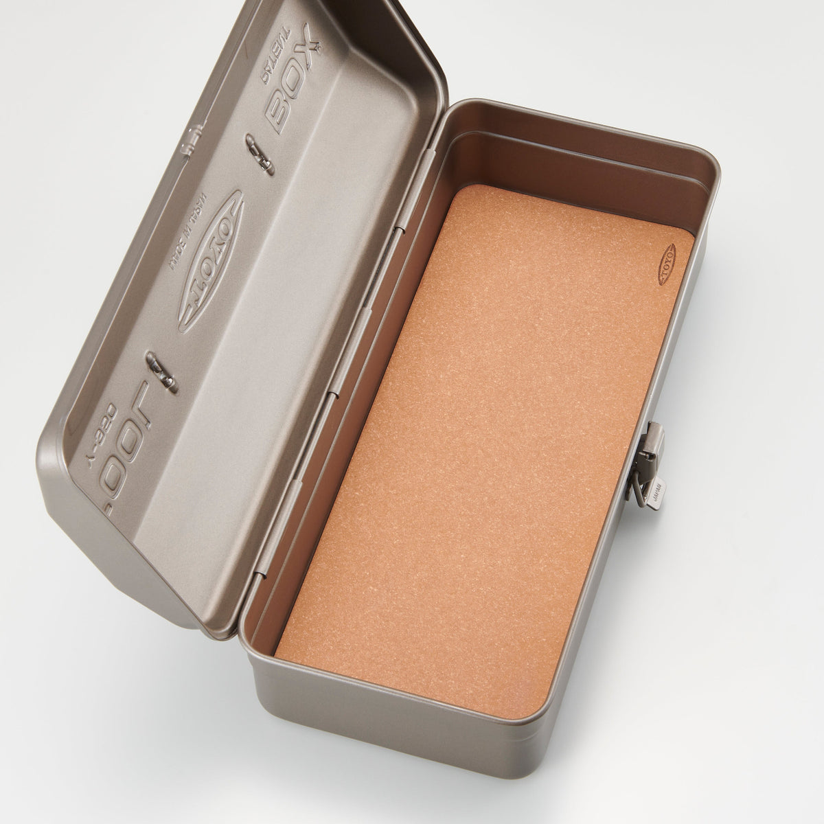 Open metal tin box with brown interior on a white background