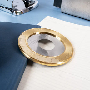 Gold and silver circular object on a blue and white surface