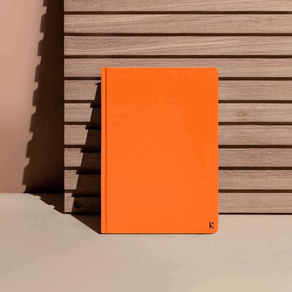 Orange notebook against a wooden slat background