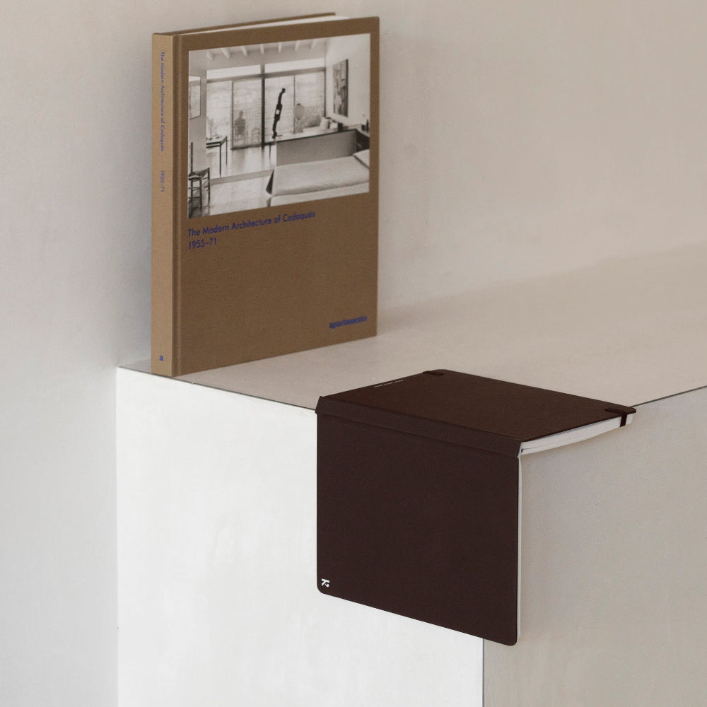 Book on a white surface with a brown box next to it