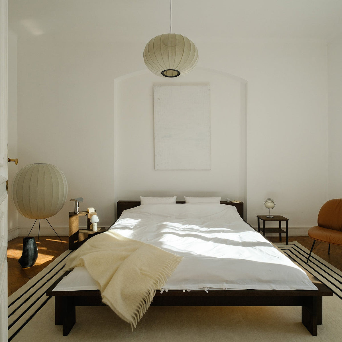 Modern bedroom with a bed, side tables, and a lamp.