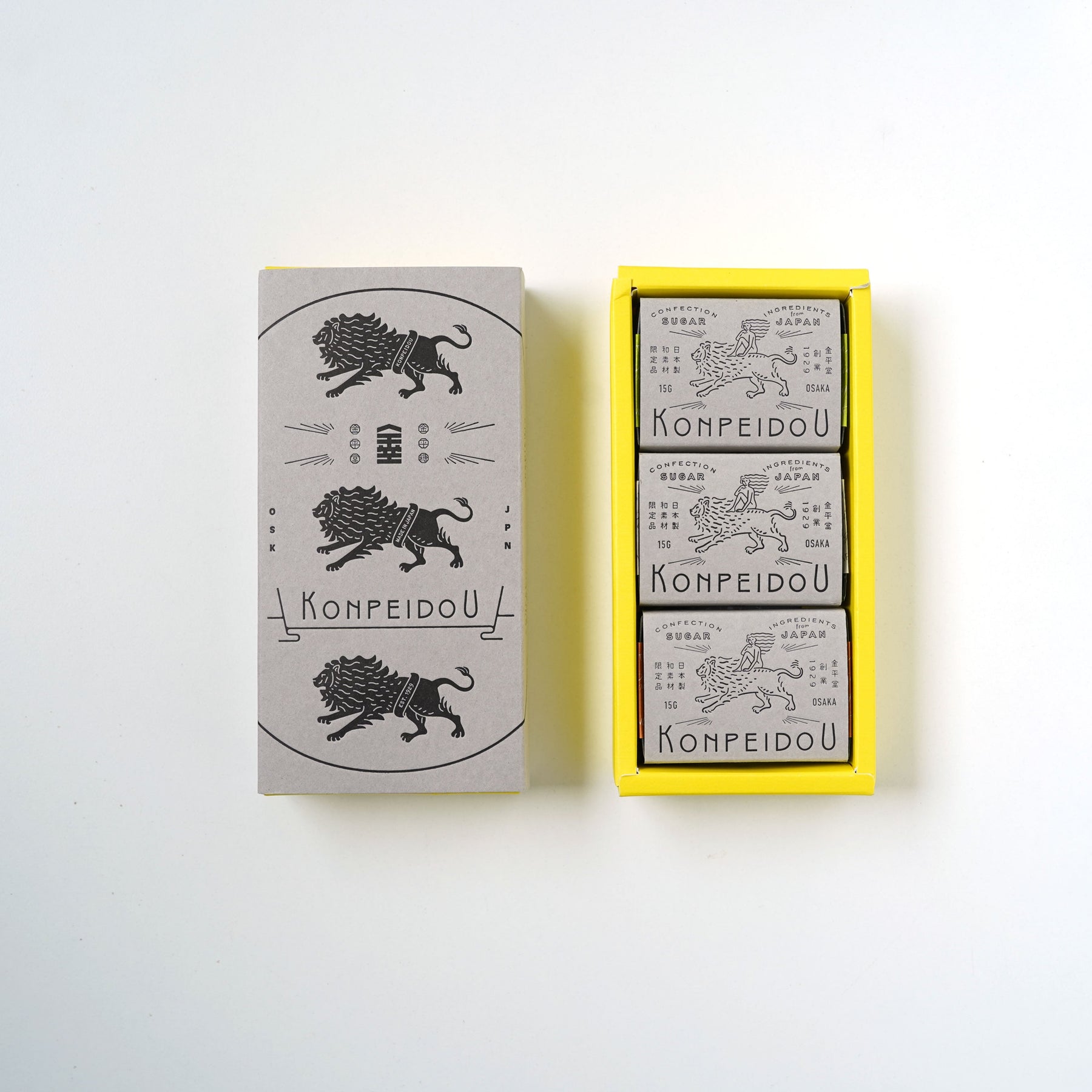 A set of three matchboxes from the brand KOMPEIDOU, displayed on a clean white background. The set includes one closed matchbox with a gray cover featuring a black illustration of a lion and the brand name, and an open yellow tray containing three individual matchboxes with gray covers.