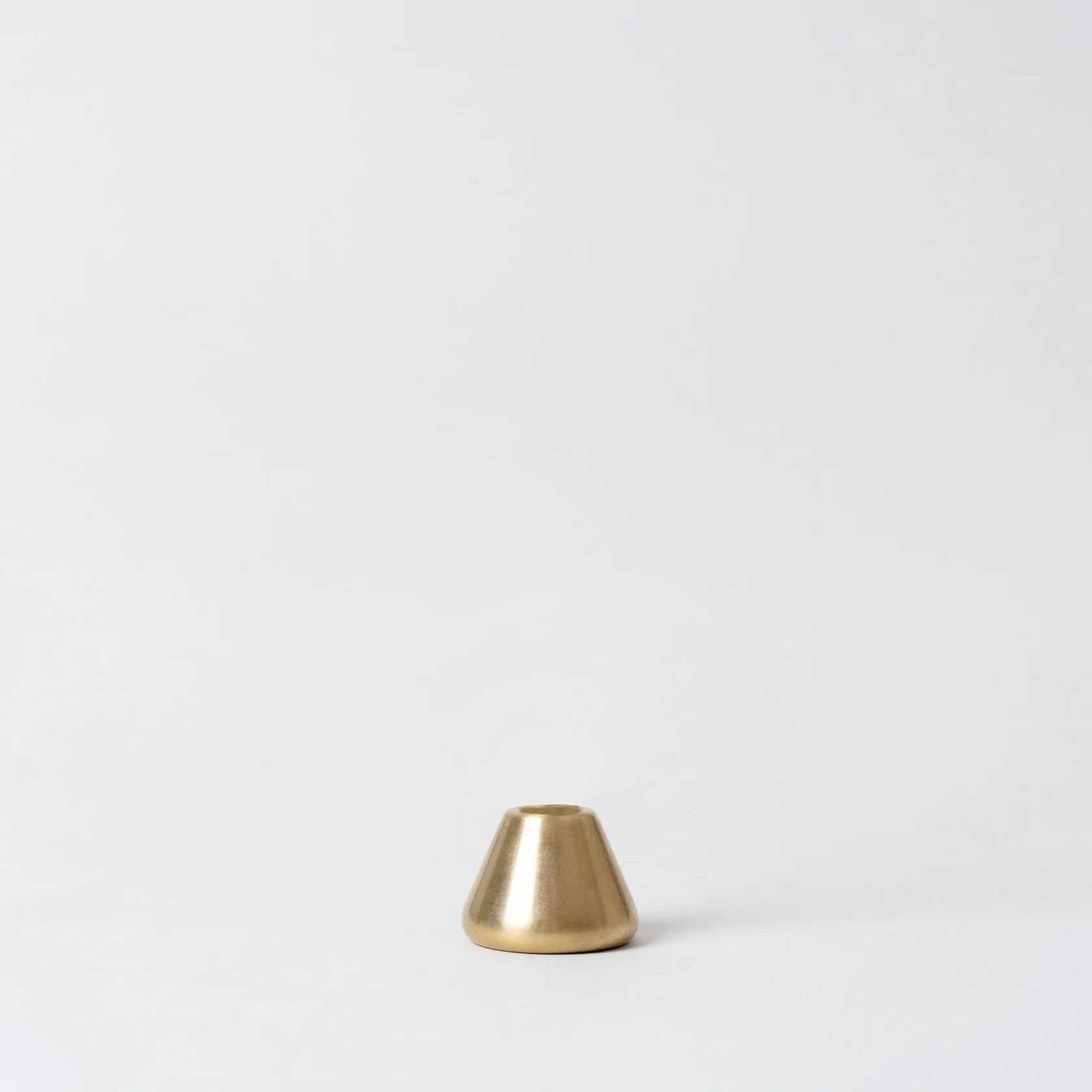 Small brass cone-shaped object on a white background