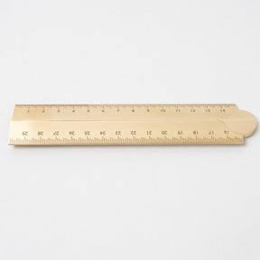 Minimalist brass ruler with engraved measurement markings, featuring a warm brushed metal finish, clean edges, and a smooth surface on a plain white background.