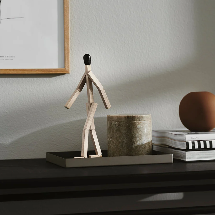 Wooden sculpture on a shelf with a minimalistic background