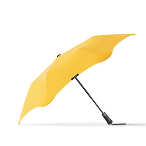 Yellow umbrella with black handle on a white background
