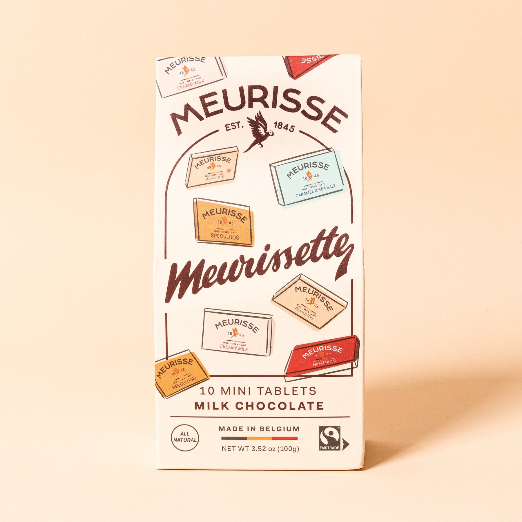 Front view of Meurisse Meurissette milk chocolate packaging, a cream-colored box illustrated with assorted mini chocolate tablets, labeled ‘10 mini tablets,’ made in Belgium.