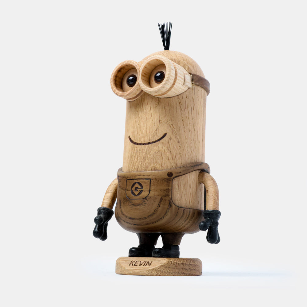 Wooden figurine of an animated cartoon character carved from light and dark wood, featuring a tall cylindrical body, round goggle-style eyes, a subtle carved smile, engraved clothing details, small sculpted arms with dark gloves, visible natural wood grain, and a matte surface on a plain white background.
