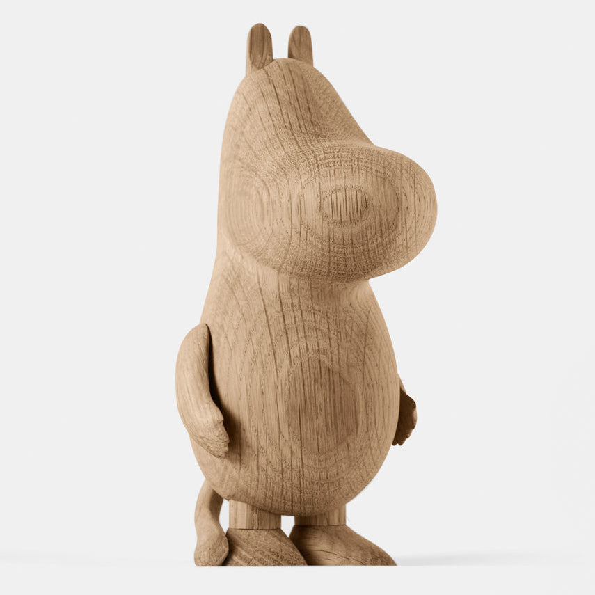 Wooden figurine of an animated cartoon character carved from light oak, featuring a rounded elongated head with small ear details, a smooth sculpted body, simplified limbs, visible natural wood grain, and a matte surface on a plain white background.