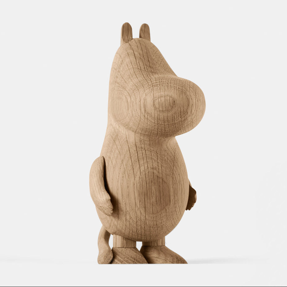Wooden figurine of an animated cartoon character carved from light oak, featuring a rounded elongated head with small ear details, a smooth sculpted body, simplified limbs, visible natural wood grain, and a matte surface on a plain white background