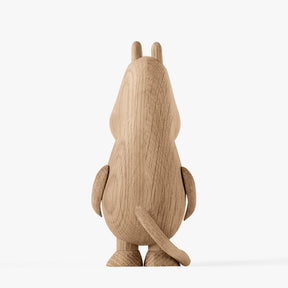 Back view of a wooden figurine of an animated cartoon character carved from light oak, featuring a tall rounded body with small ear details, smooth sculpted arms and tail, visible natural wood grain, and a matte surface on a plain white background.