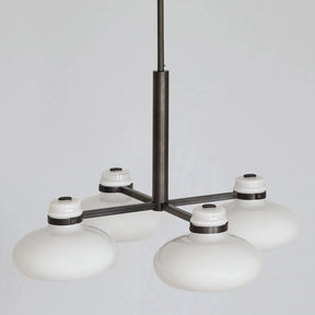 Modern chandelier with white glass shades on a gray background