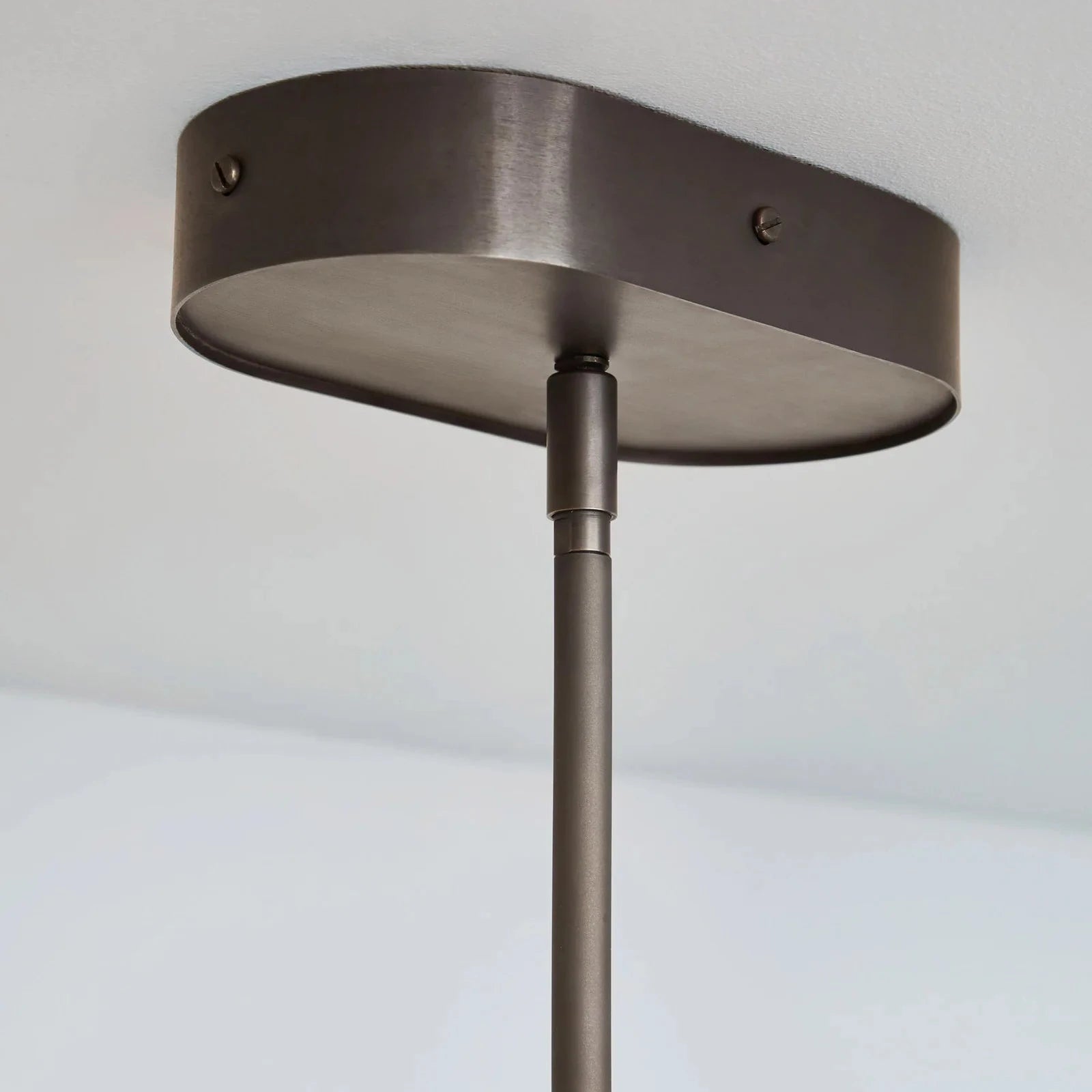 Ceiling light fixture with a dark finish on a plain background