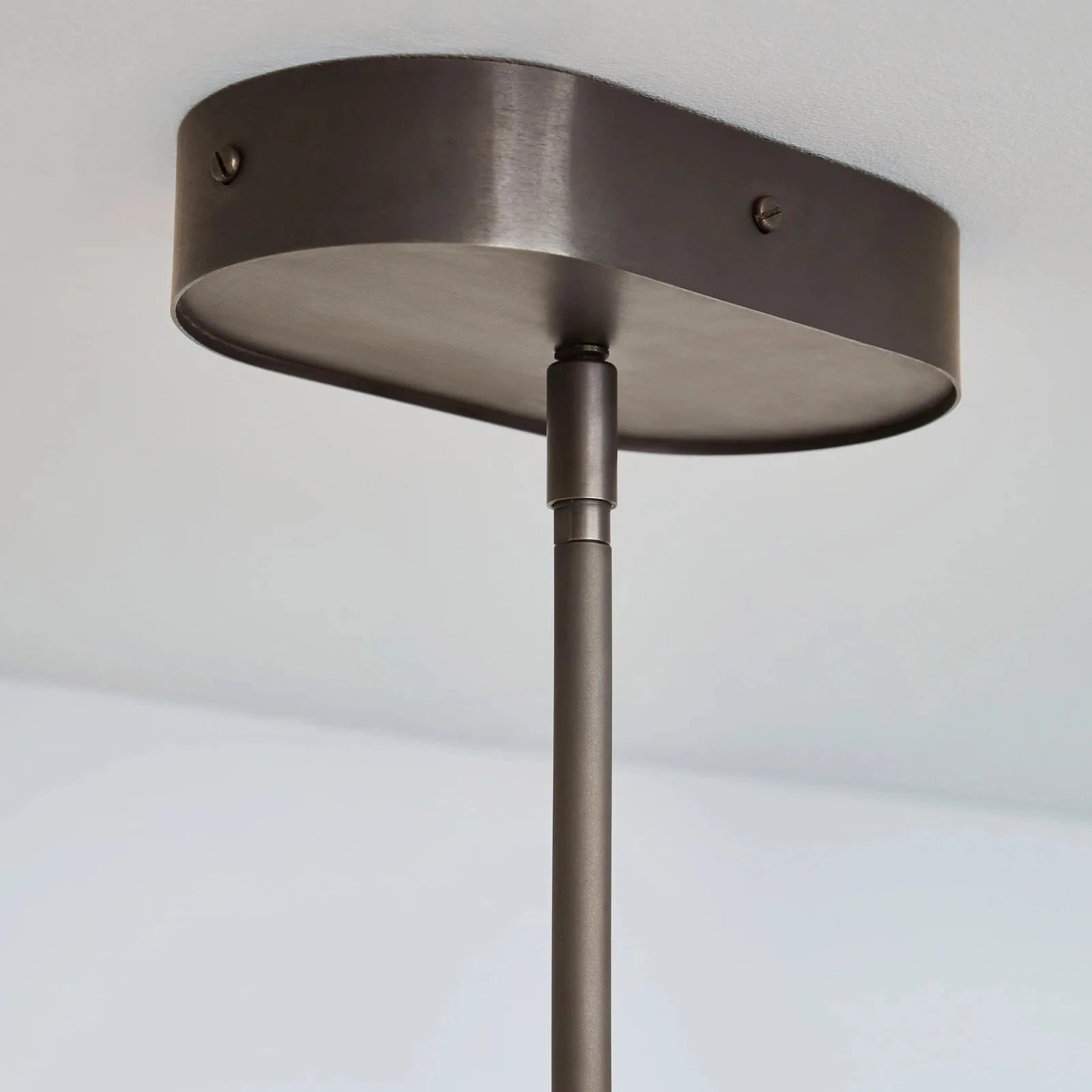Ceiling light fixture with a dark finish on a plain background