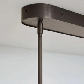 Close-up of a dark metal pendant light fixture against a plain background