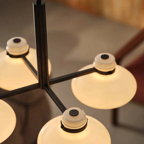 Modern chandelier with multiple round lampshades on a blurred background
