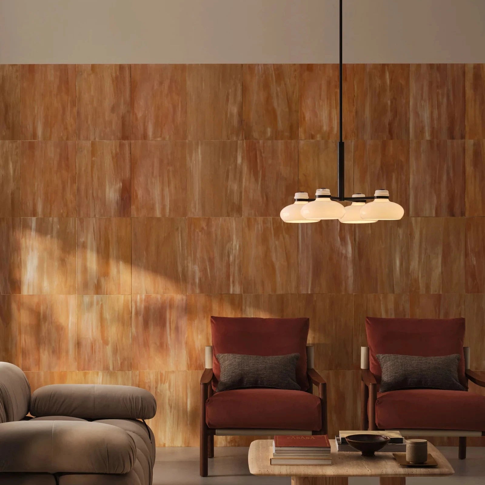 Modern living room with wooden wall, chairs, and a pendant light.