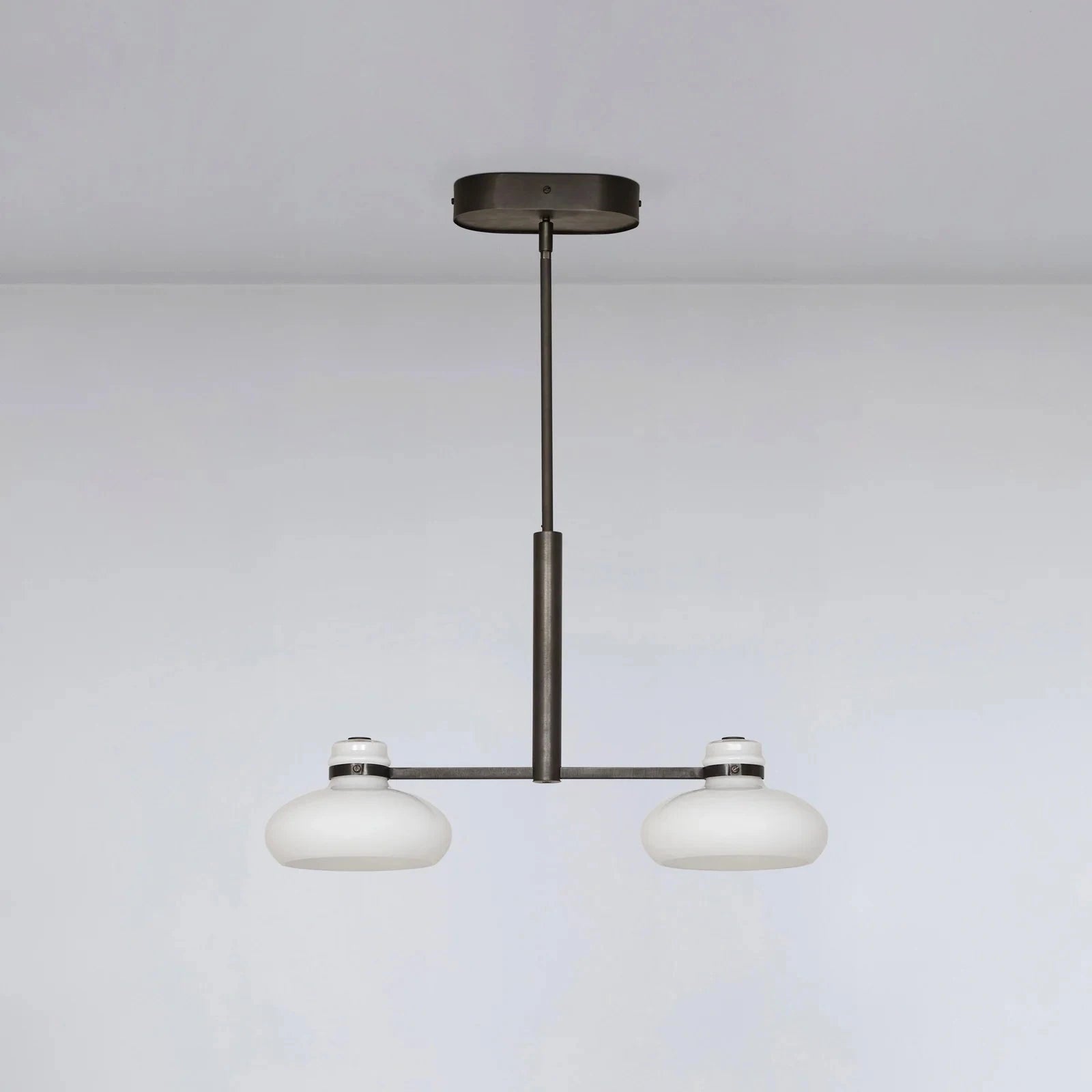 Modern pendant light with two round glass shades on a plain background
