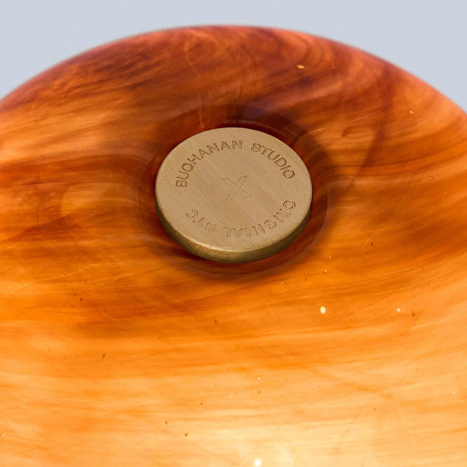 Wooden cutting board with a visible brand logo on a light gray background