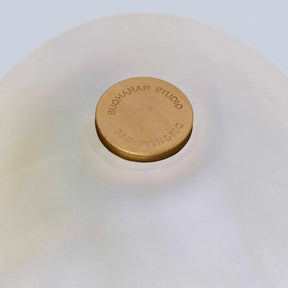 Close-up of a white ceramic bowl with a gold lid featuring 'Bloom & Co' branding.
