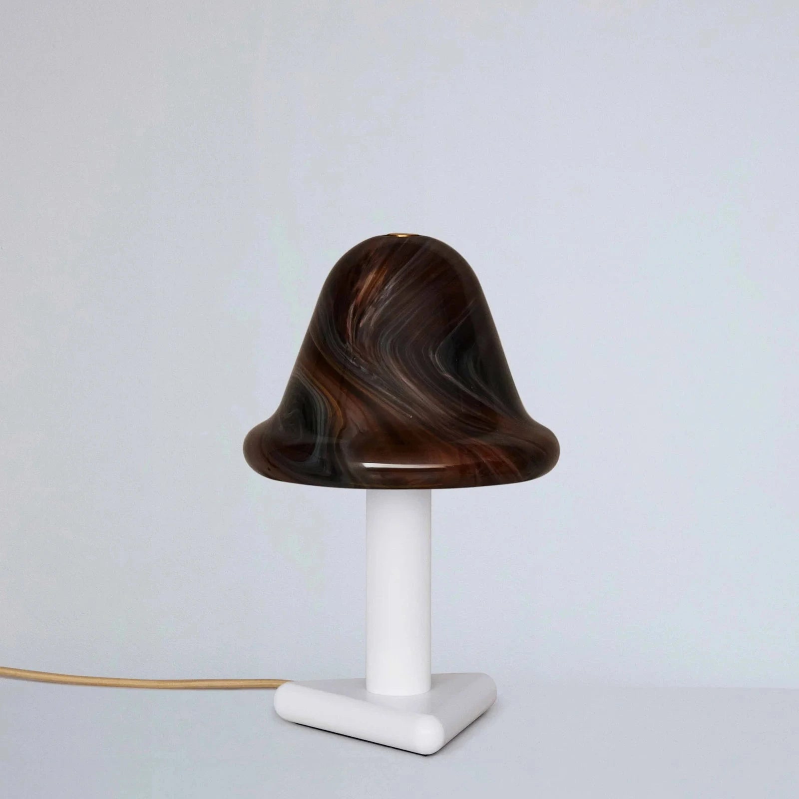 Table lamp with a brown marbled shade on a white base against a light gray background