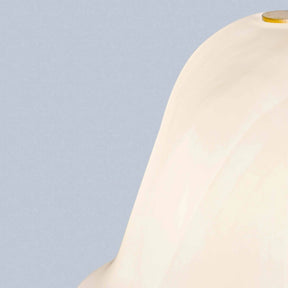 Close-up of a beige lampshade against a light blue background