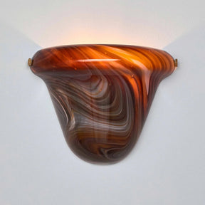 Decorative wall sconce with brown and orange marbled design on a light gray background