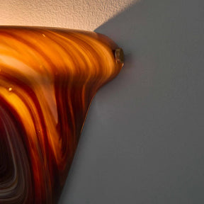 Close-up of a glass object with swirl patterns on a plain background