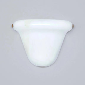 A vintage-style white wall sconce with a smooth, curved shade and small brass-colored wall mounts on each side, shown against a solid gray background.