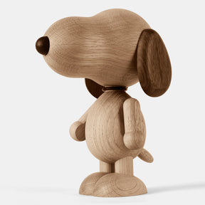 Wooden figurine of an animated cartoon character carved from smoked oak, featuring an elongated rounded head, darker ear and nose details, simplified body and limbs, visible natural wood grain, and a smooth matte surface on a plain white background.
