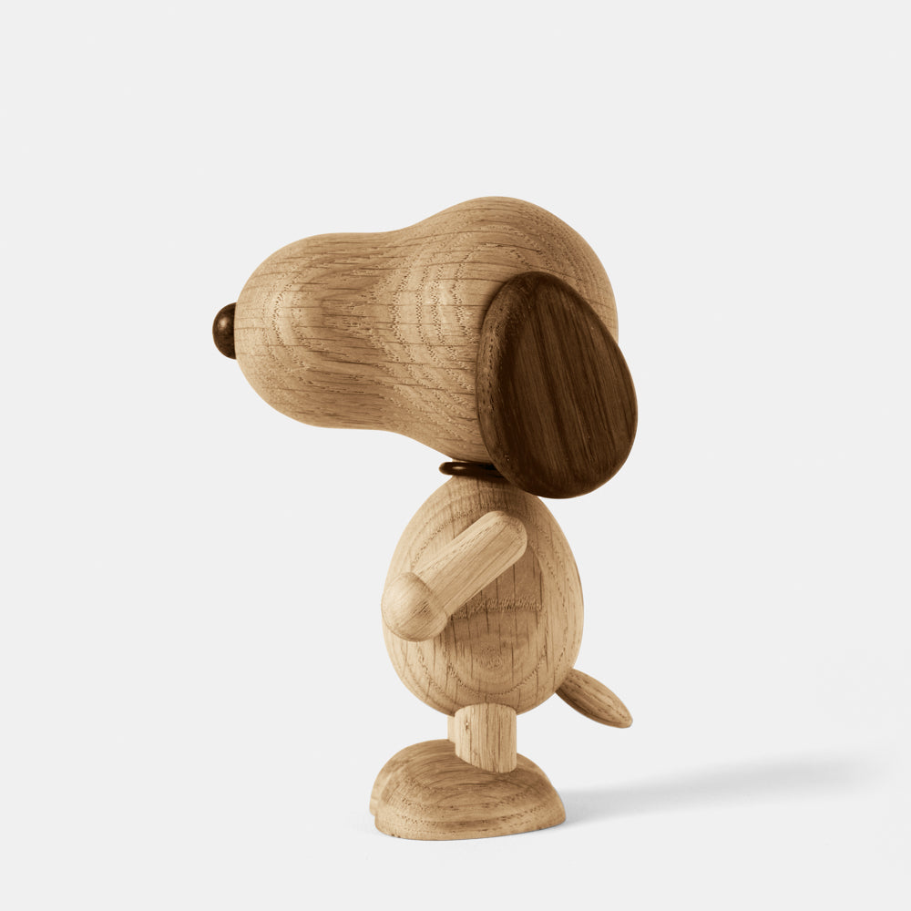 Wooden figurine of an animated cartoon character carved from smoked oak, featuring an elongated rounded head, darker ear and nose details, simplified body and limbs, visible natural wood grain, and a smooth matte surface on a plain white background.