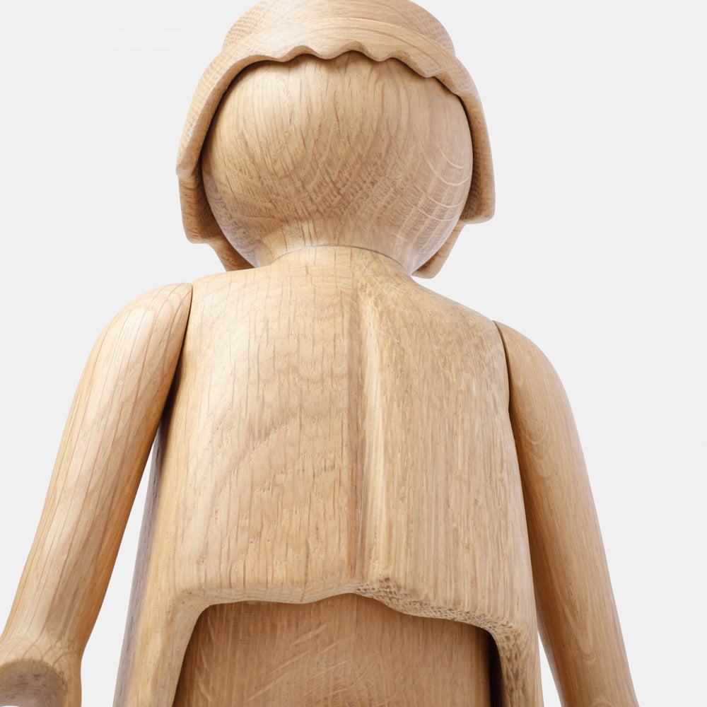 Wooden Playmobil-style human figure crafted from light oak, featuring a rounded head with carved hair detail, smooth sculpted torso and arms, visible natural wood grain, and a matte surface on a plain white background.