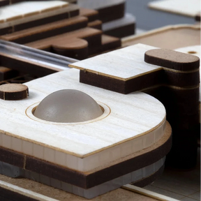 Close-up of a wooden model train track with detailed components.