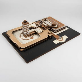 Wooden mechanical model on a black base with a white background