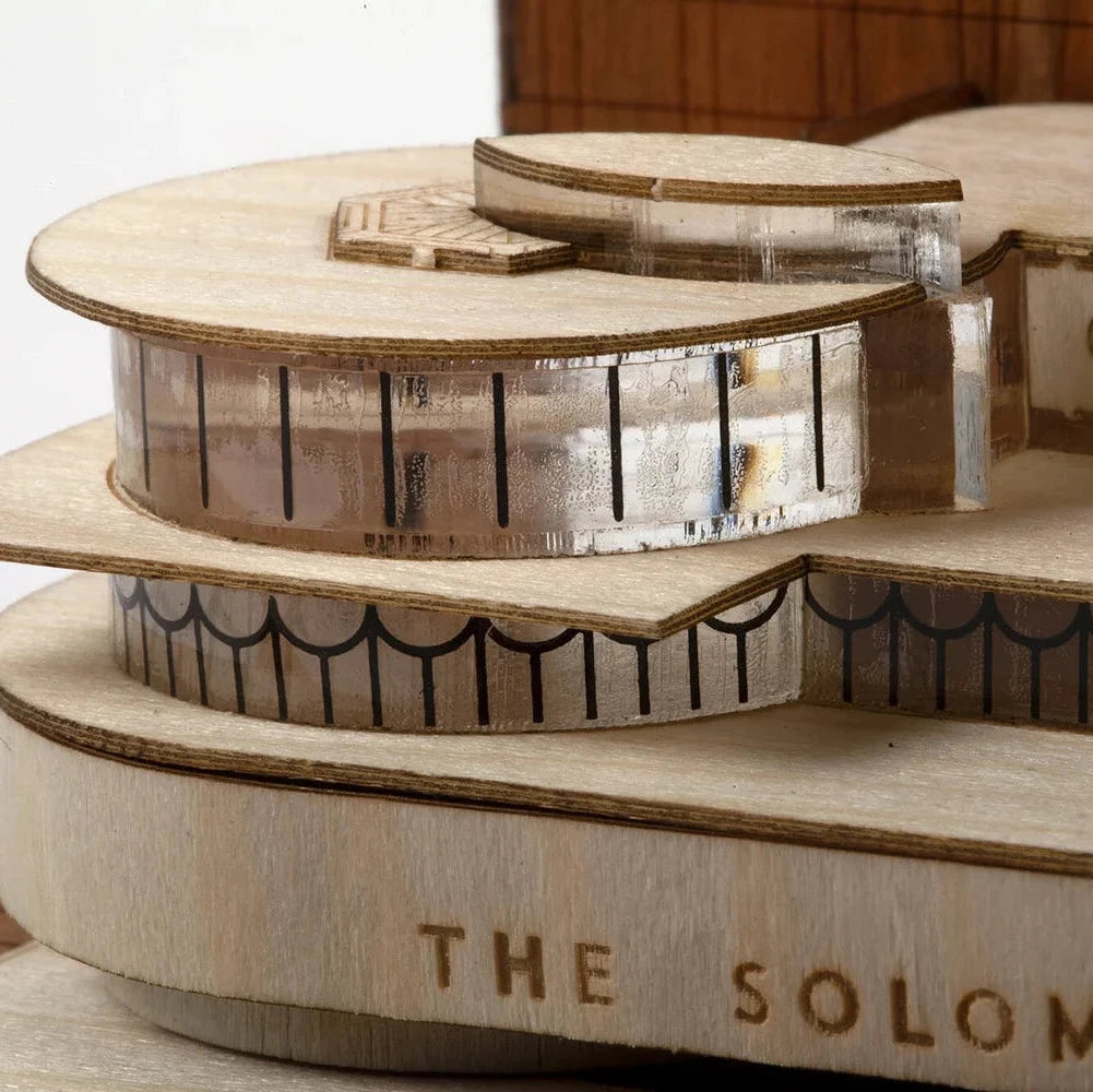 Wooden model of a building named 'The Solomon' on a white background