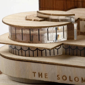 Wooden model of a building named 'The Solomon' on a white background