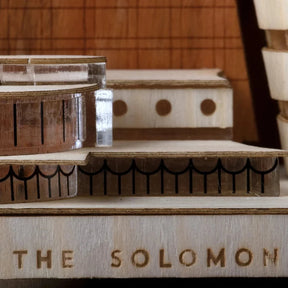 Wooden model of a building with 'The Solomon R' branding on a wooden surface.