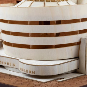 Close-up of a wooden model with 'Guggenheim Museum' branding on a wooden surface.