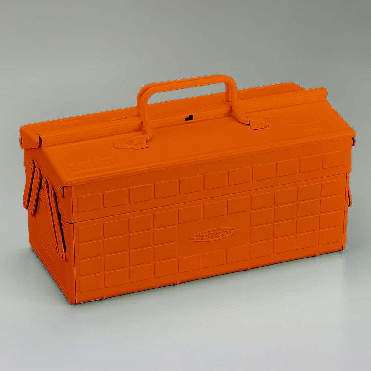 Orange Toyo steel cantilever toolbox, closed, three-quarter front view with raised carry handle.