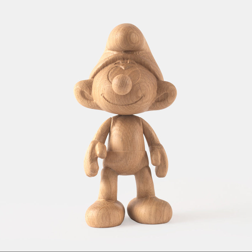 Wooden figurine of a small animated cartoon character, carved from light oak, featuring a rounded hat, smiling facial details, simplified body proportions, visible natural wood grain, and a smooth matte surface on a plain white background.