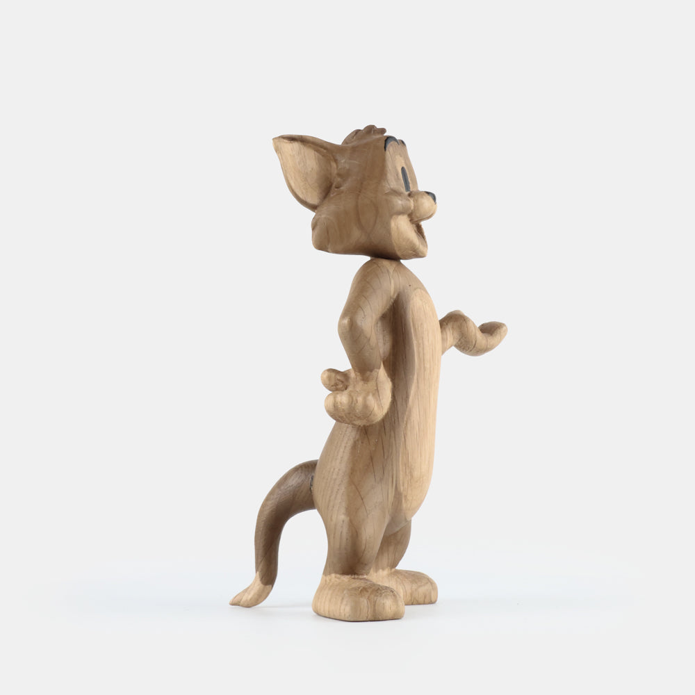 Wooden figurine of an animated cartoon mouse character, carved from light-toned wood, featuring expressive facial details, rounded ears, a standing pose with one hand raised, visible wood grain, and a smooth matte surface on a plain white background.