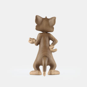 Wooden figurine of an animated cartoon mouse character, carved from light-toned wood, featuring expressive facial details, rounded ears, a standing pose with one hand raised, visible wood grain, and a smooth matte surface on a plain white background.