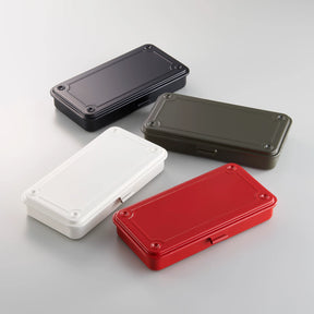 Four rectangular metal storage boxes with lids in black, olive green, white, and red, arranged on a light background.