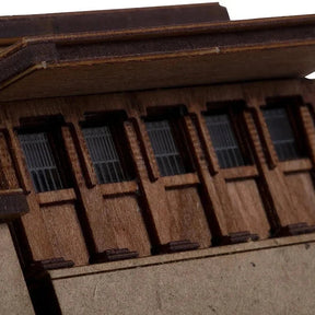 Close-up of a wooden model house with detailed windows.