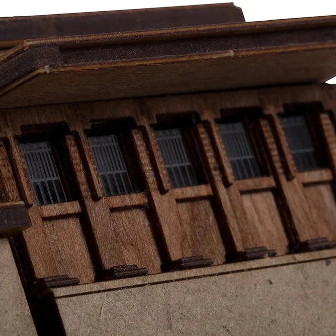 Close-up of a wooden model house with detailed windows.