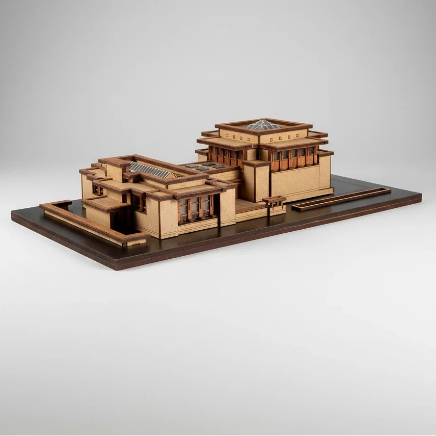 Wooden model of a building on a dark brown base with a white background