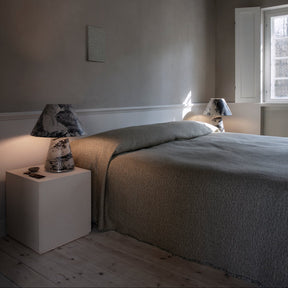 Minimalist bedroom with a bed, nightstands, and lamps.