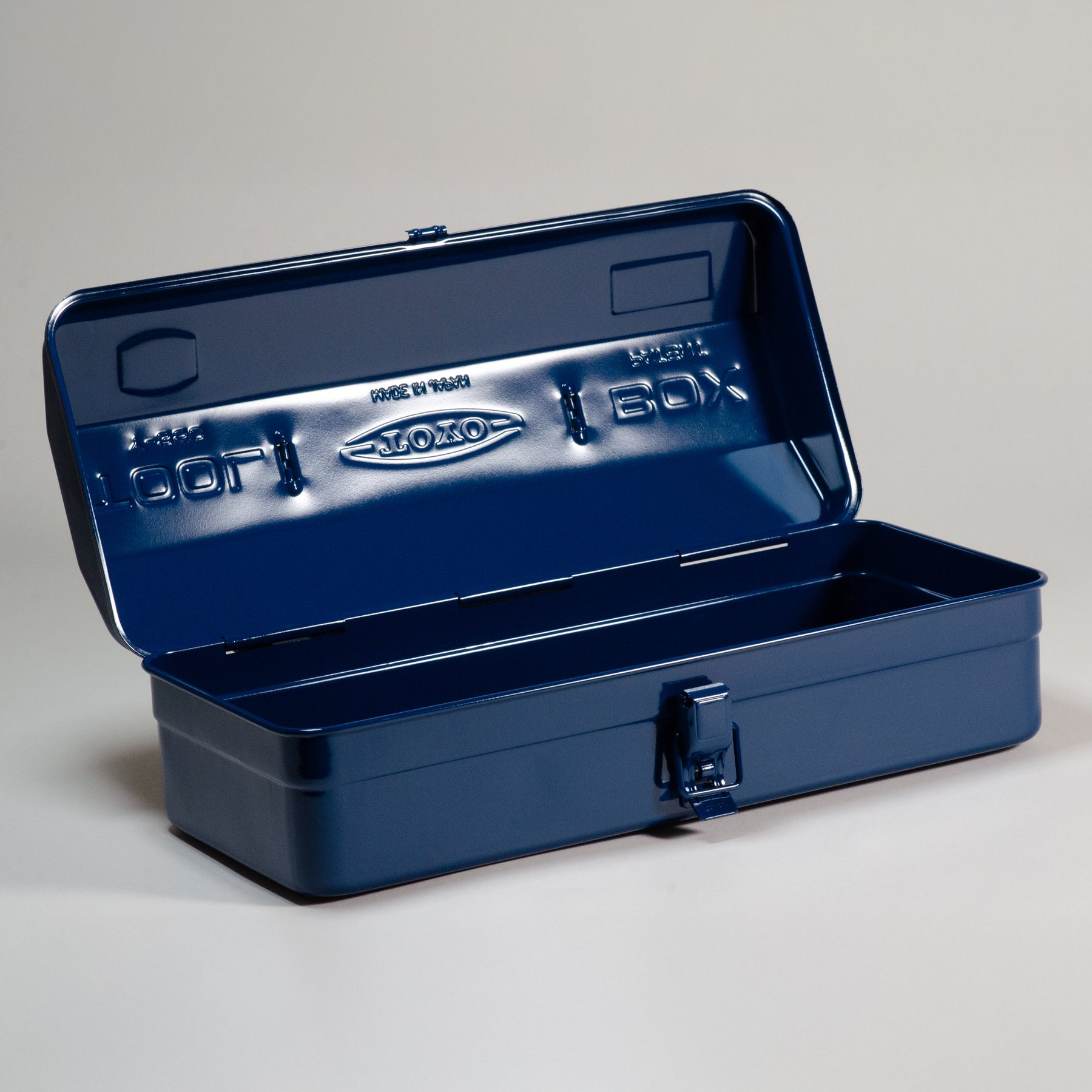 Open indigo Toyo Steel Y-350 metal toolbox with hinged lid and front latch, shown empty on a neutral studio background.