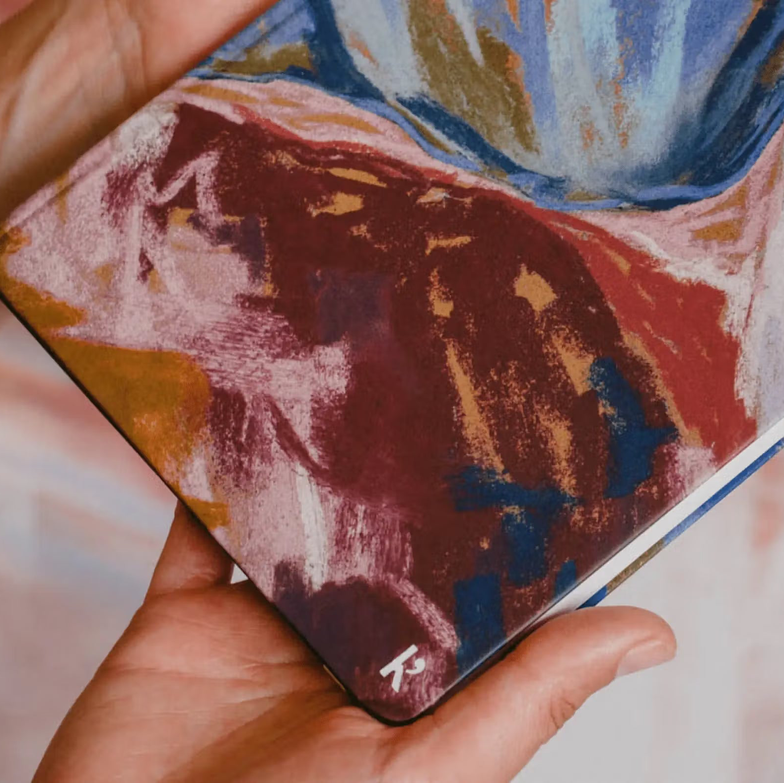 Hand holding a colorful notebook with abstract design